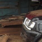 The car inside the damaged wooden shop