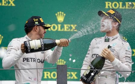 Lewis Hamilton sprays champagne into Nico Rosberg's face Credit- AP