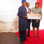 Chief Ade-Ojo(L) presenting a cheque award of N2 million to the representative of FG Department of Petroleum Resources