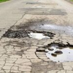 Pits of water on the asphalt road in the forest